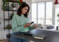 Eine Frau überträgt zu Hause ihre Daten von einem Android-Smartphone auf ein iPhone.