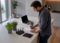 Zu Hause schreibt sich ein Mann die Zugangsdaten für seinen WLAN-Router auf.