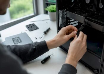 Mit den Händen werden PC-Komponenten eigenhändig eingebaut und verbunden.