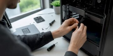 Mit den Händen werden PC-Komponenten eigenhändig eingebaut und verbunden.