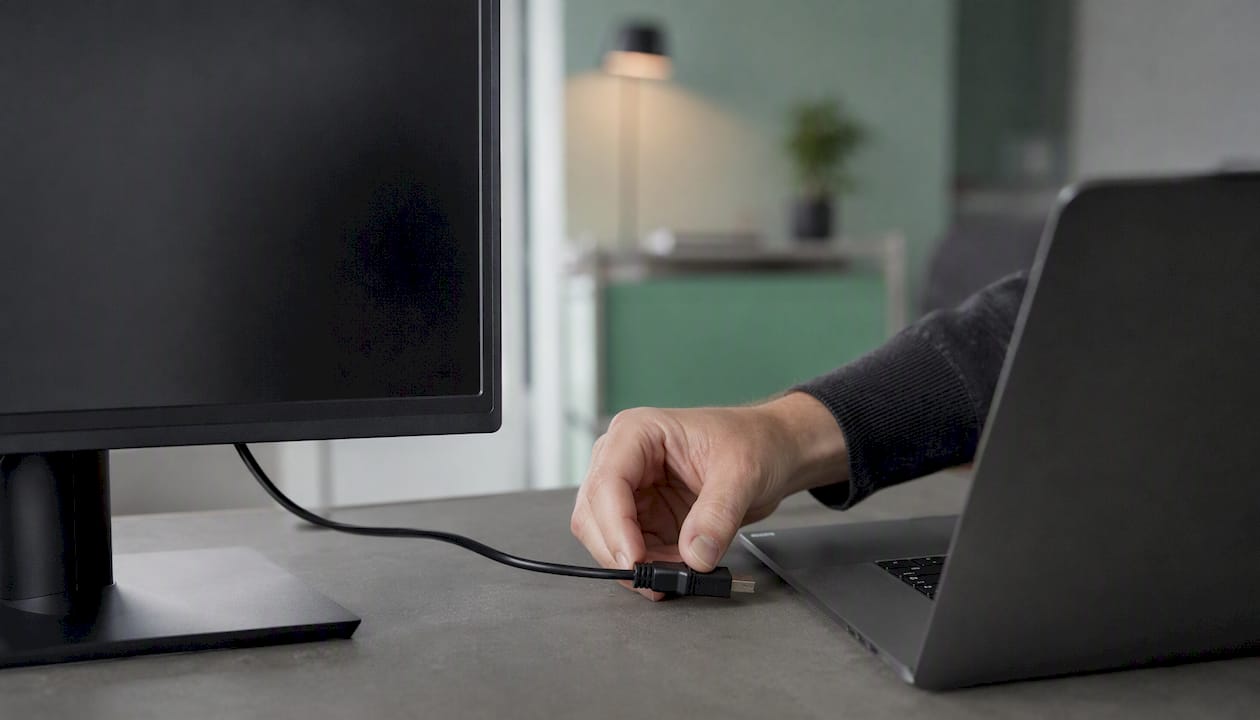 Ein externer Monitor ist per HDMI-Kabel an den Laptop angeschlossen.