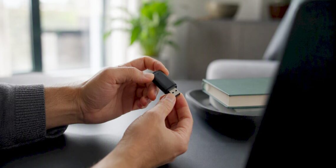 Jemand hält einen Bluetooth-Adapter in der Hand und steckt ihn gerade in den PC.