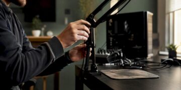 Jemand richtet sein Streaming-Equipment auf dem Gaming-Schreibtisch ein.