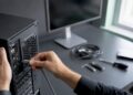 Ein Techniker zieht das Netzwerkkabel vom Rechner ab.