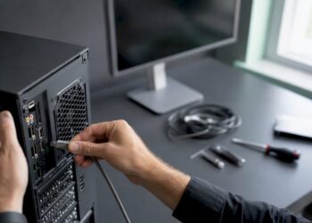 Ein Techniker zieht das Netzwerkkabel vom Rechner ab.