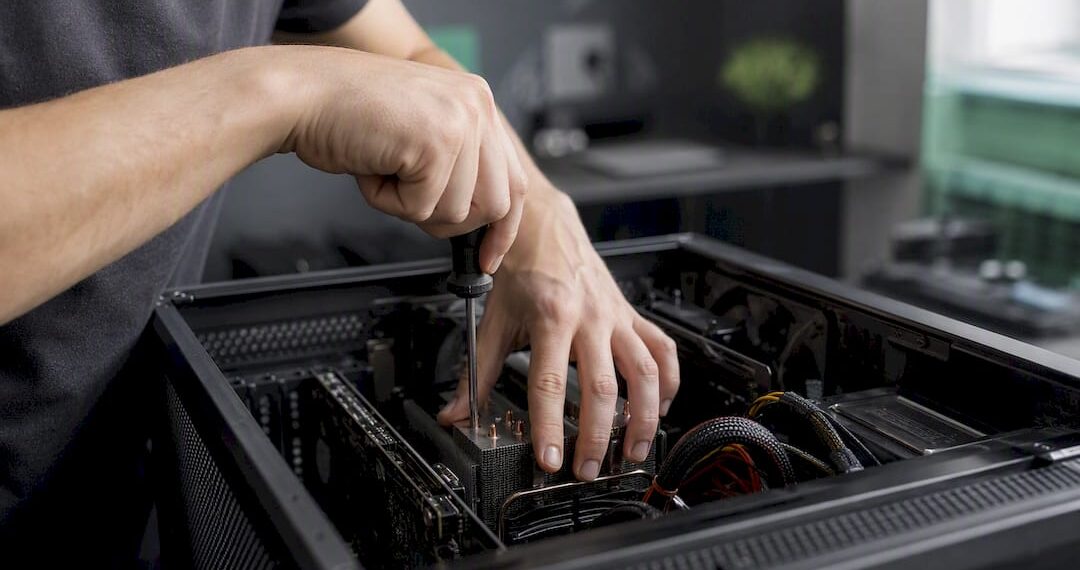 Jemand arbeitet mit den Händen am geöffneten PC-Gehäuse und repariert die Hardware.