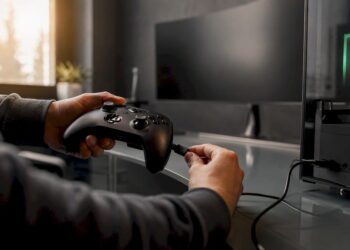Hände verbinden den Gamecontroller mit einem USB-Kabel