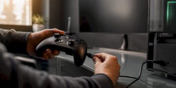 Hände verbinden den Gamecontroller mit einem USB-Kabel