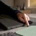 Hände, die den Laptop während eines Windows-Updates neu starten