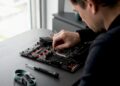 Hände entfernen den CMOS-Jumper auf dem Motherboard