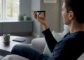 Hände ziehen das Smartphone-Ladegerät aus der Steckdose