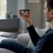 Hände ziehen das Smartphone-Ladegerät aus der Steckdose