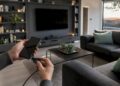 Hände verbinden Smartphone mit dem Fernseher per Kabel