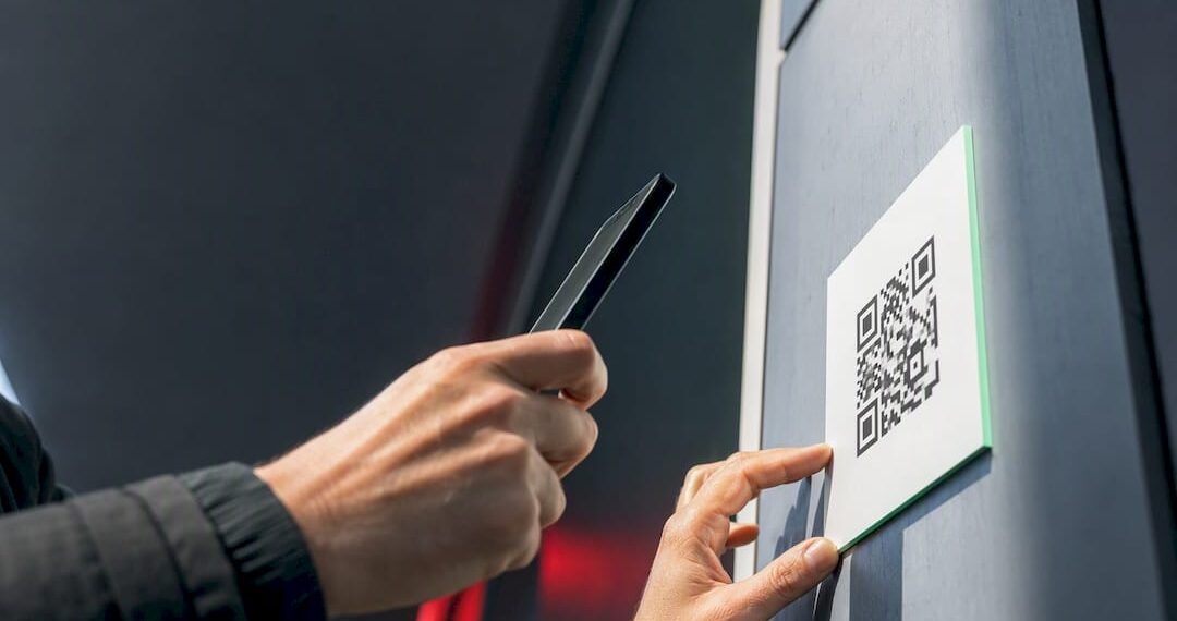 Hand scannt QR-Code auf einem öffentlichen Aushang