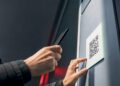 Hand scannt QR-Code auf einem öffentlichen Aushang