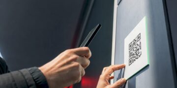 Hand scannt QR-Code auf einem öffentlichen Aushang
