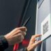 Hand scannt QR-Code auf einem öffentlichen Aushang