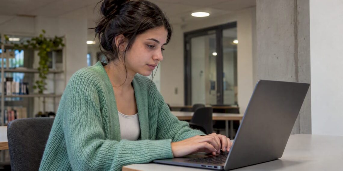 Studentin legt am Laptop einen E-Mail-Alias an
