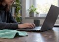 Laptop mit staubigen Lüftungsschlitzen auf dem Schreibtisch