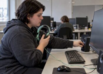 Die Studentin kontrolliert die Audioausgabe am PC