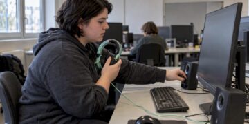 Die Studentin kontrolliert die Audioausgabe am PC