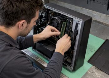 Ein Techniker installiert ein RAM-Modul auf einem Mainboard.