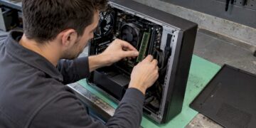 Ein Techniker installiert ein RAM-Modul auf einem Mainboard.