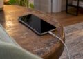 iPhone mit Ladekabel auf einem Nachttisch